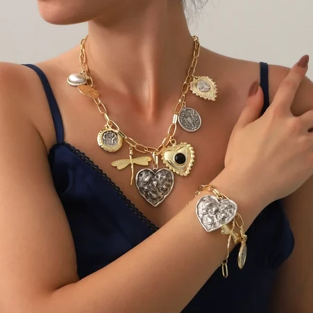 Collier et bracelet en or porte bonheur avec pendentifs en forme de cœur.